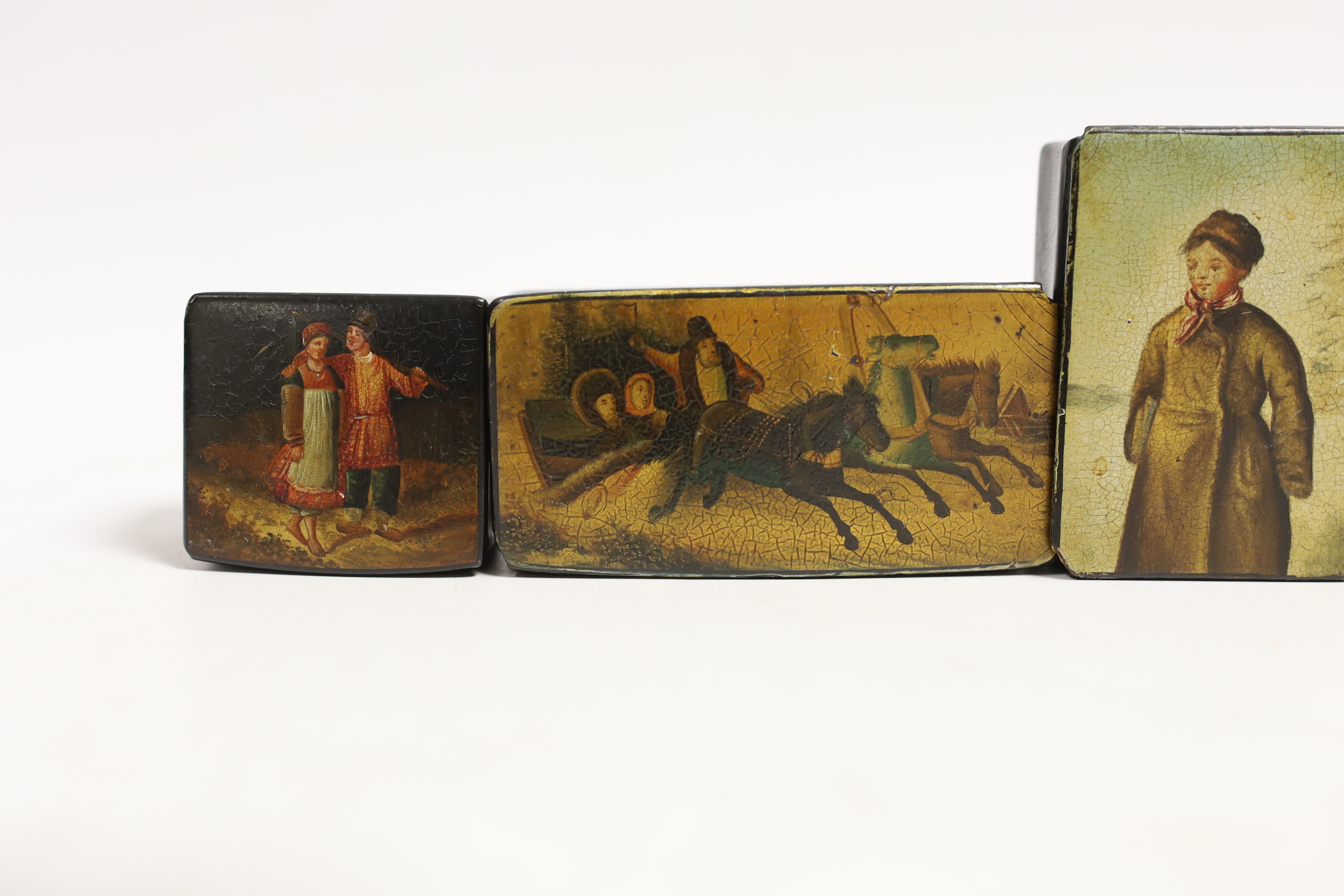 Four small Russian lacquer snuff boxes and a napkin ring, by Vishnyakov, painted with Troika and figure scenes, largest 7.7 cm wide (5)